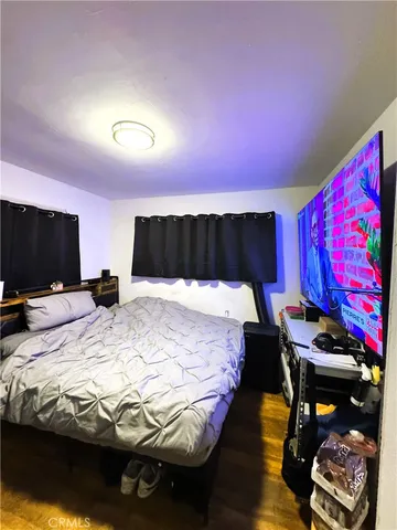 a bed sitting in a bedroom and a flat screen tv