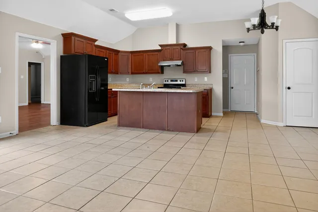 a kitchen with stainless steel appliances granite countertop a refrigerator and a stove