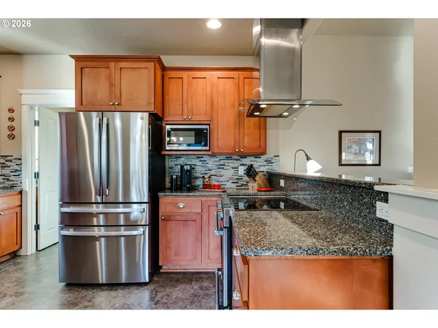 a kitchen with stainless steel appliances granite countertop a refrigerator stove and microwave