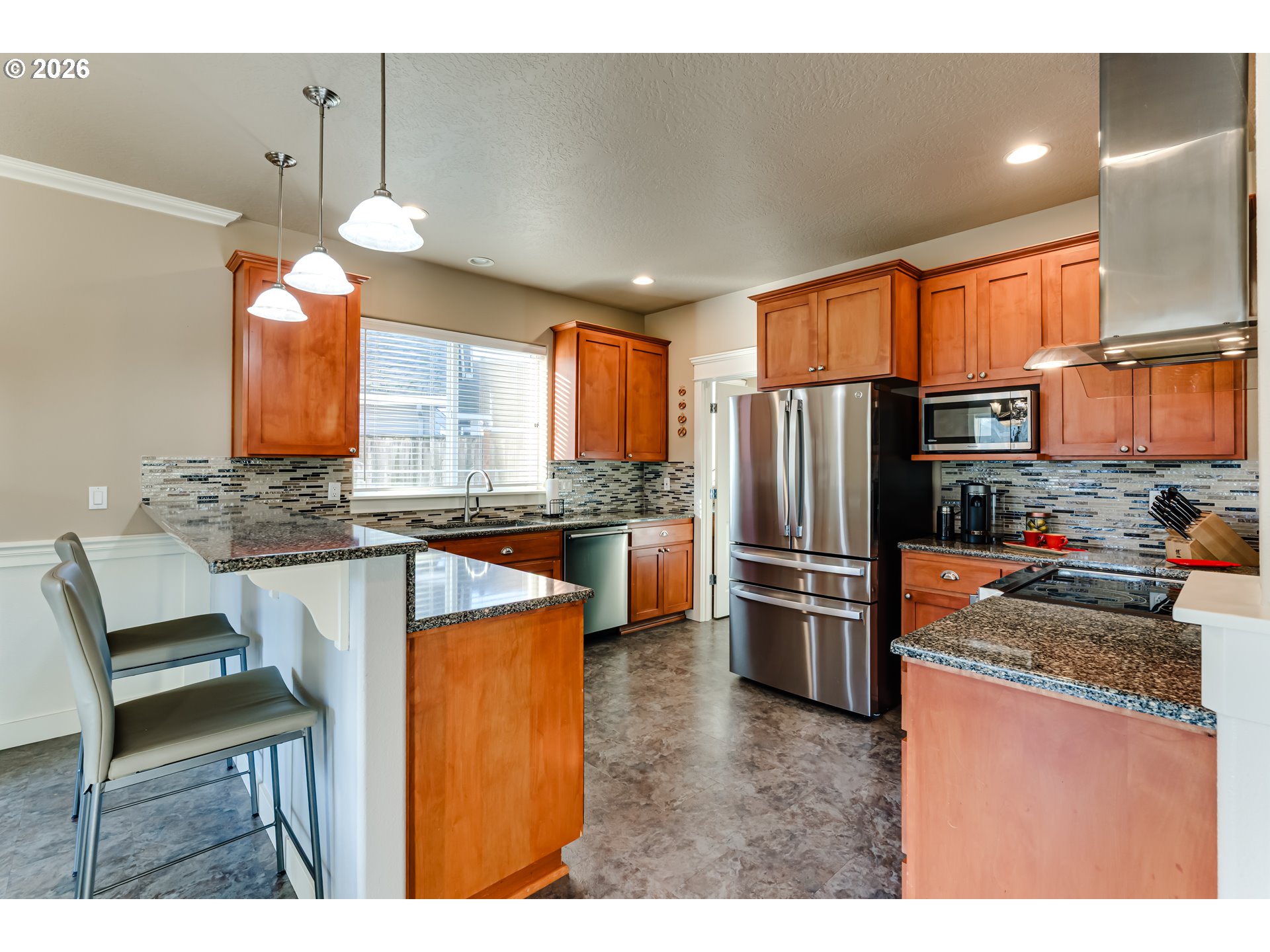90 Daniel Drive Eugene, OR 97404 - Photo 17 of 48 a kitchen with stainless steel appliances kitchen island granite countertop a refrigerator a stove a sink dishwasher a dining table and chairs with wooden floor