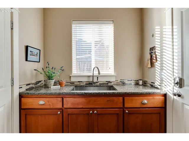 a bathroom with a granite countertop sink and a window