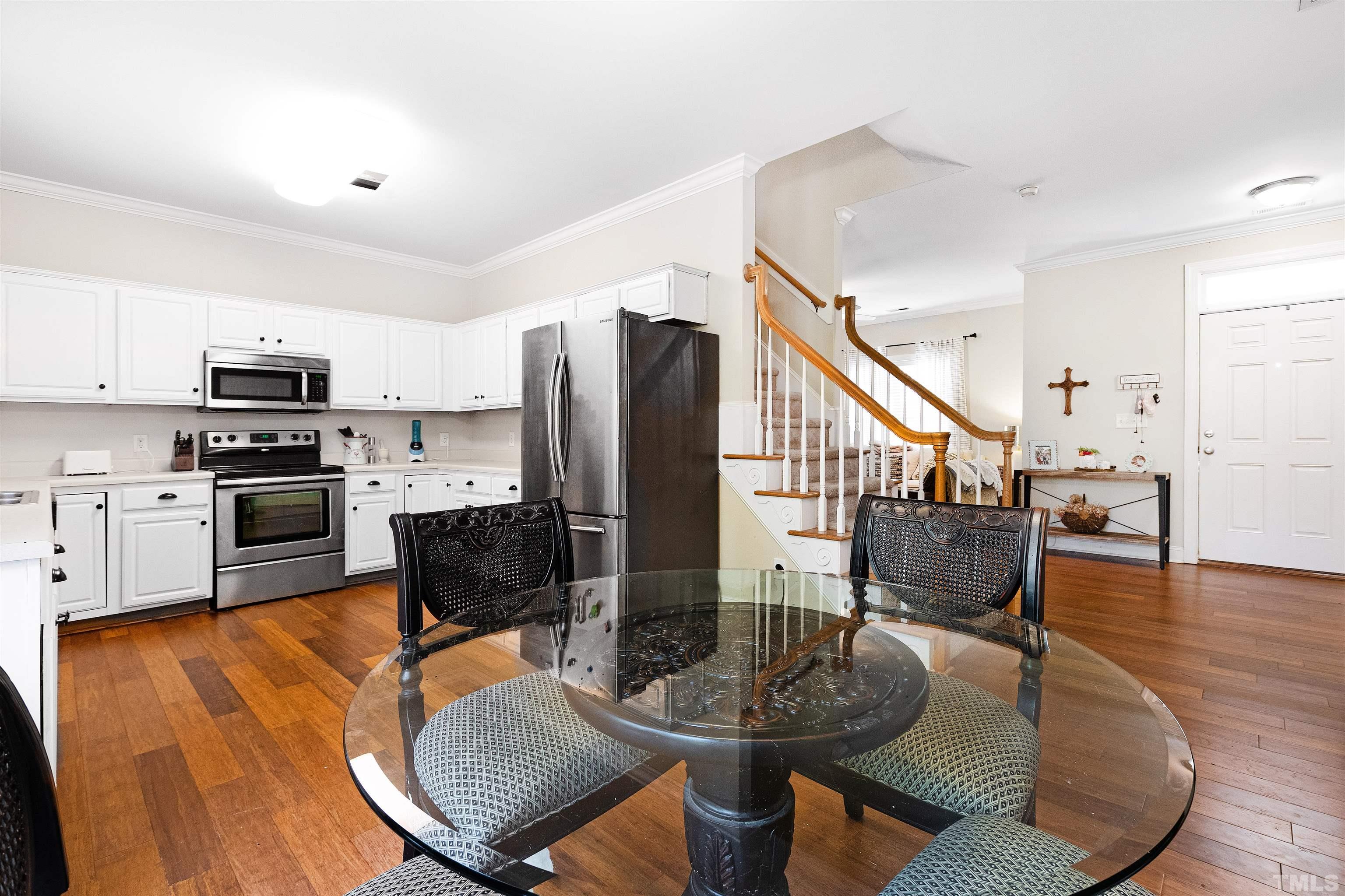 4928 Morning Edge Drive Raleigh, NC 27613 - Photo 2 of 25 a living room with stainless steel appliances kitchen island furniture and a wooden floor