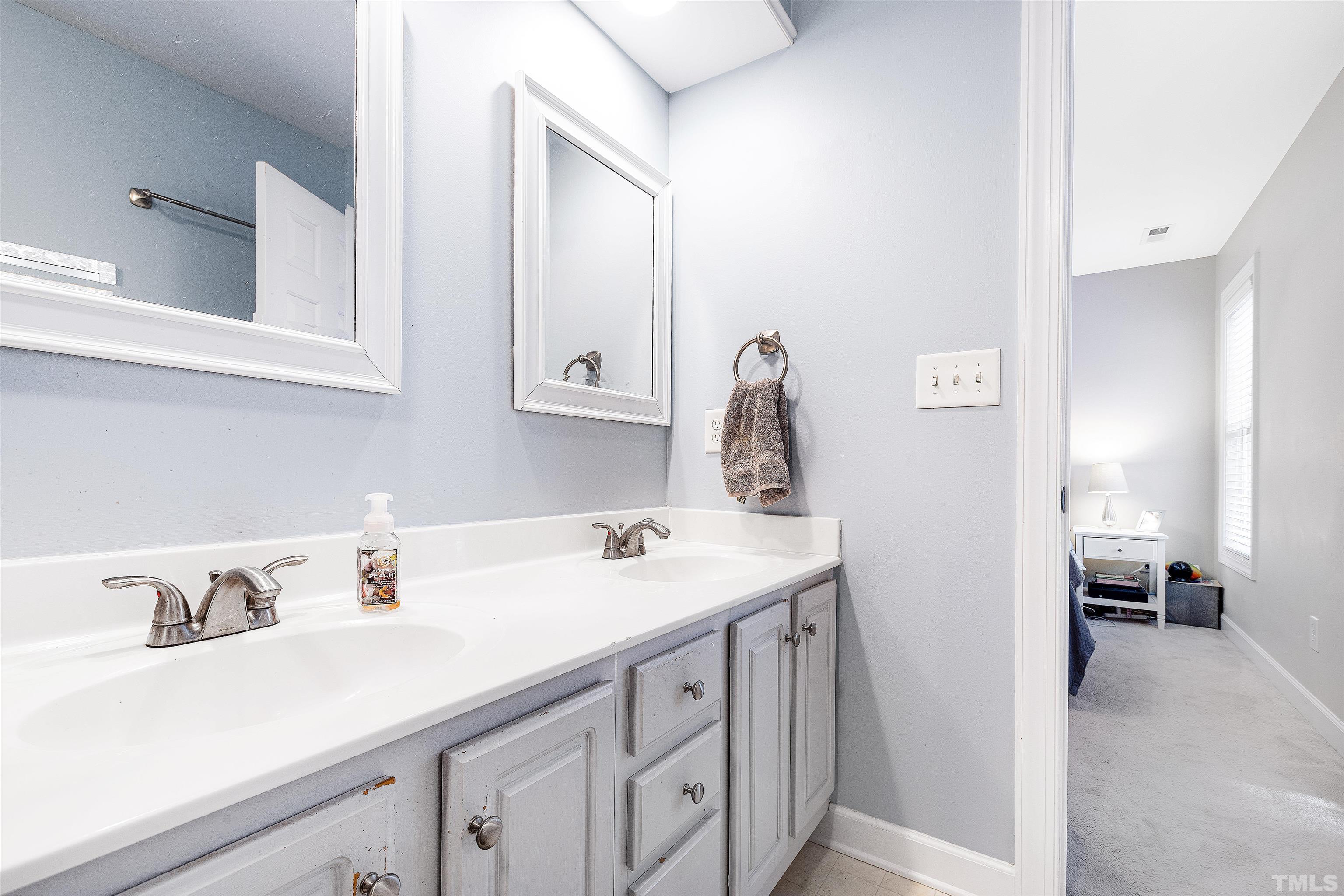 4928 Morning Edge Drive Raleigh, NC 27613 - Photo 13 of 25 a bathroom with a sink and a mirror