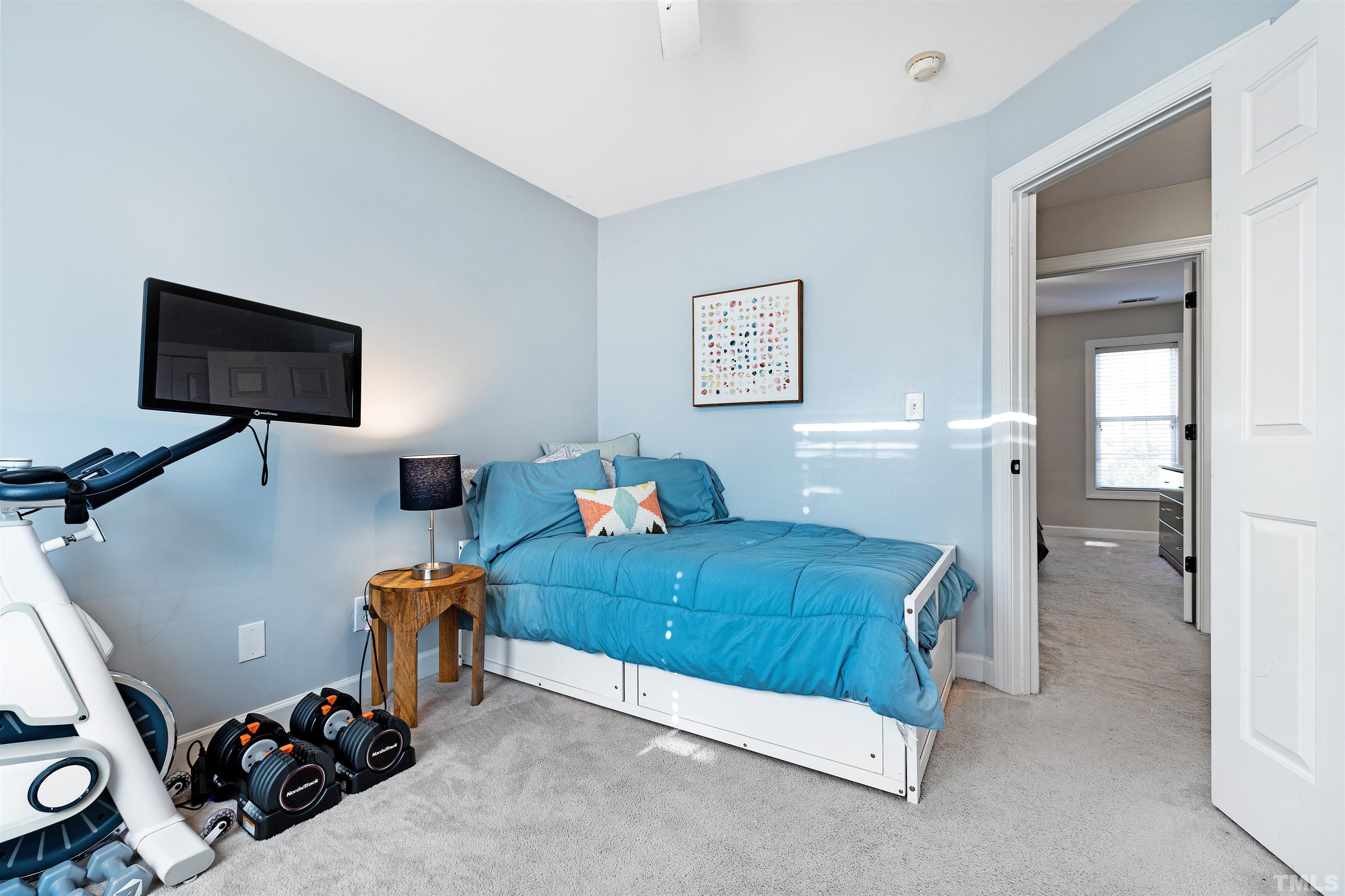 4928 Morning Edge Drive Raleigh, NC 27613 - Photo 18 of 25 a bedroom with furniture and a flat screen tv