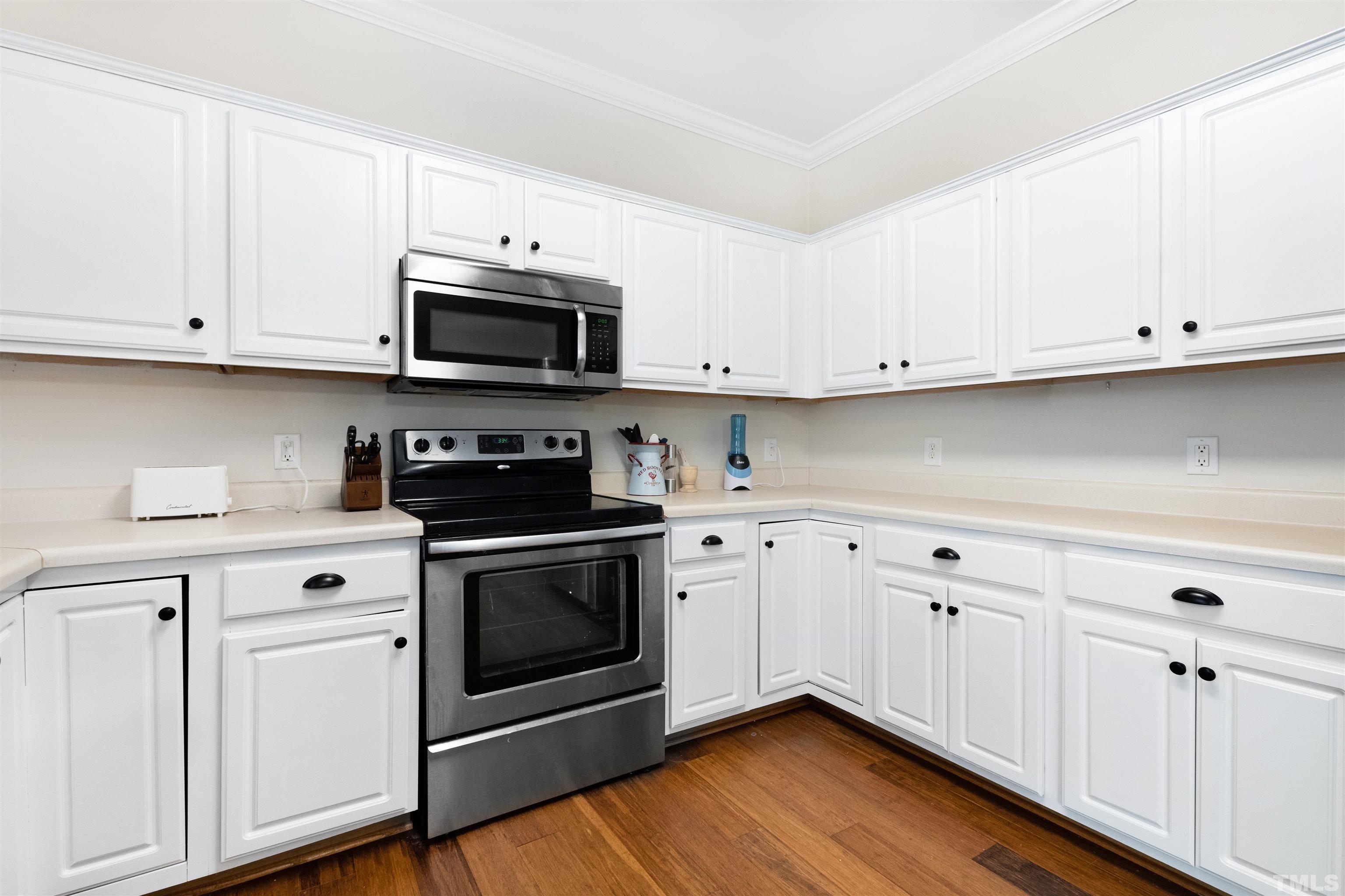 4928 Morning Edge Drive Raleigh, NC 27613 - Photo 4 of 25 a kitchen with white cabinets and stainless steel appliances