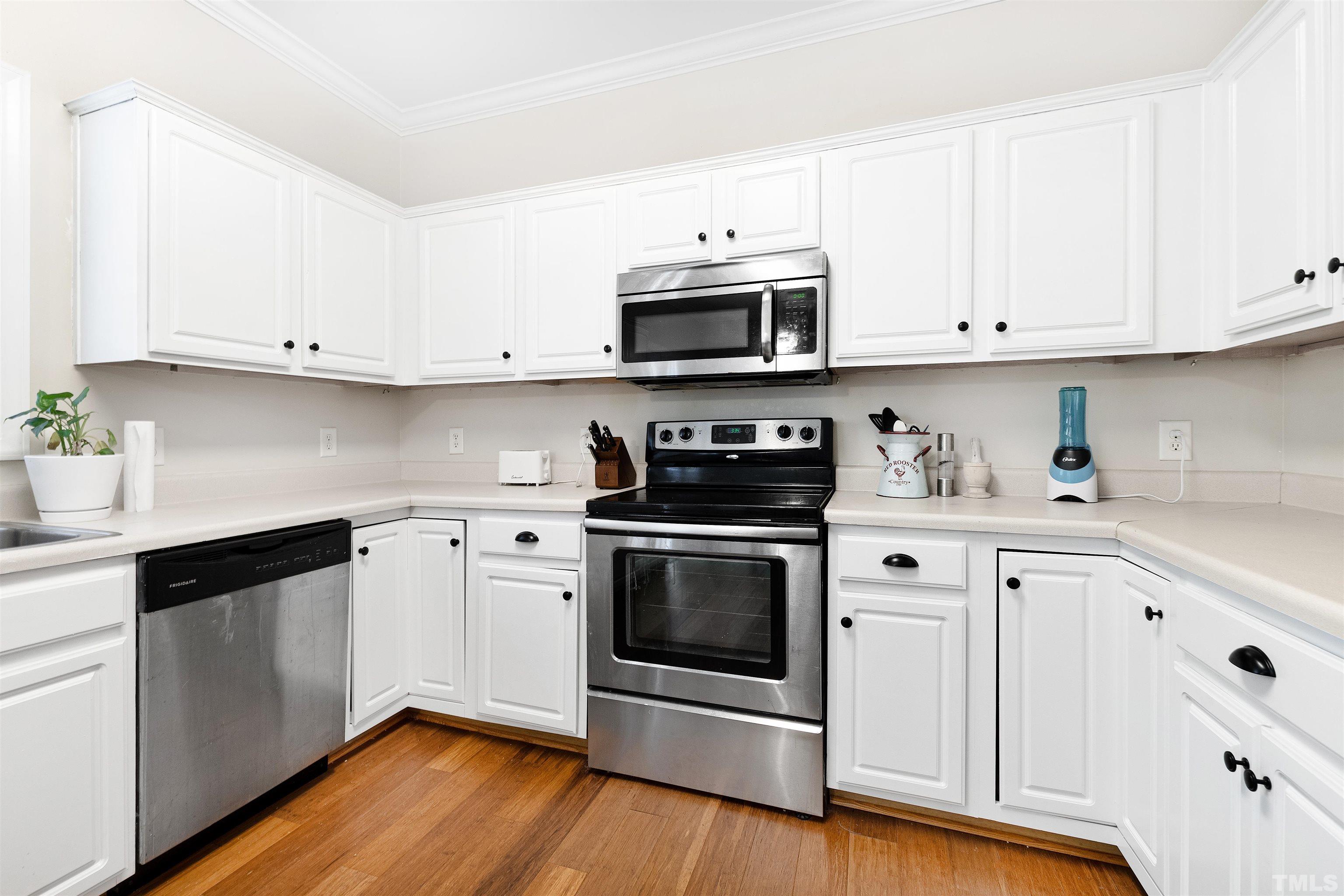 4928 Morning Edge Drive Raleigh, NC 27613 - Photo 6 of 25 a kitchen with stainless steel appliances granite countertop a sink a stove a microwave and cabinets