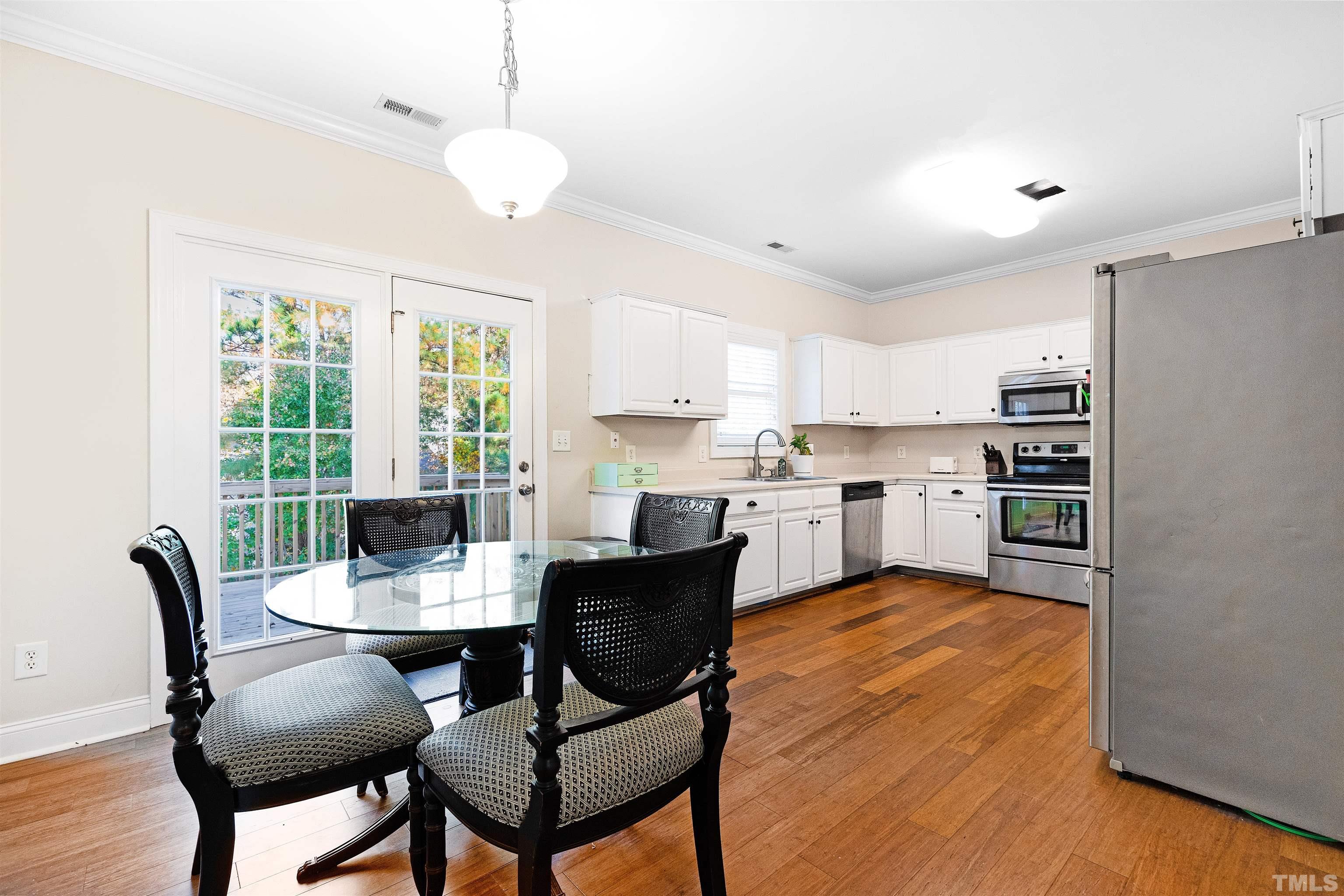 4928 Morning Edge Drive Raleigh, NC 27613 - Photo 7 of 25 a view of a dining room with furniture and a chandelier