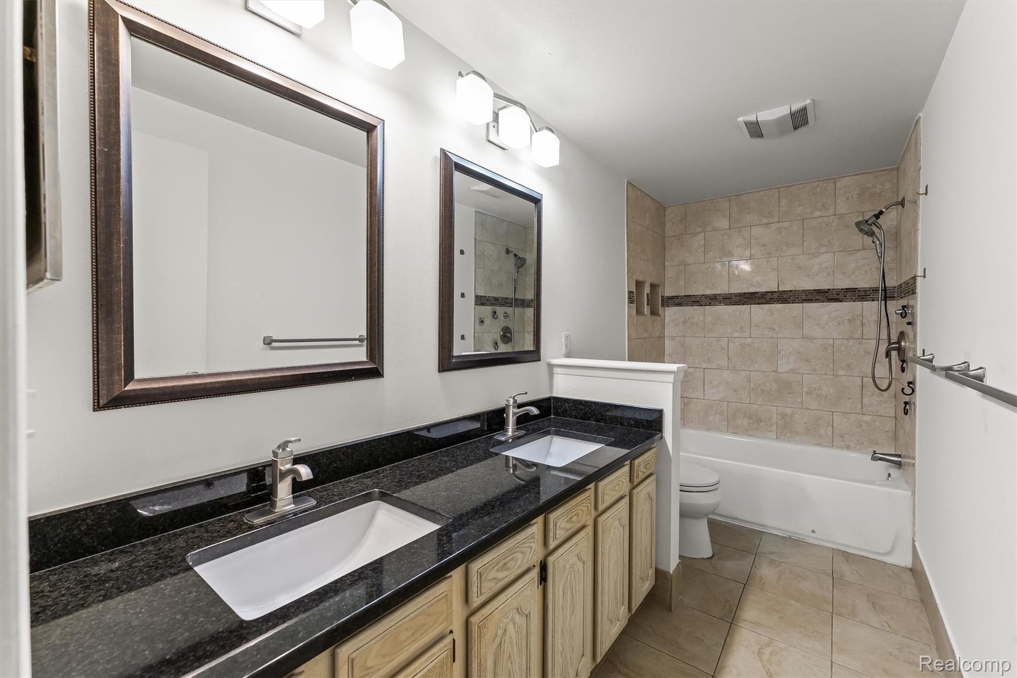 2118 Rutgers Drive Troy, MI 48085 - Photo 15 of 39 Bathroom featuring a double vanity with dark countertops and light wood cabinetry