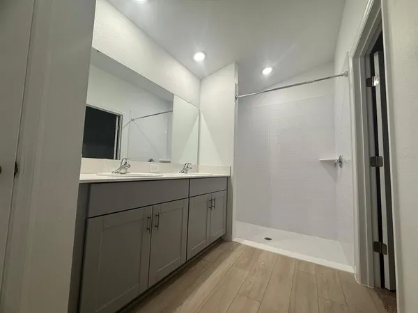 a bathroom with double vanity sink and mirror