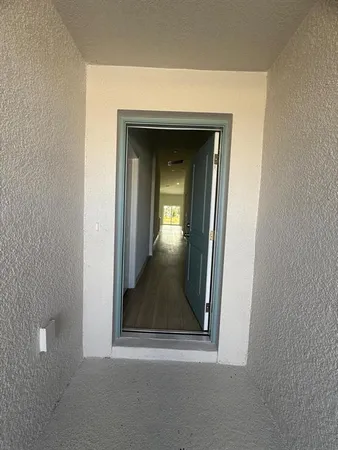 a view of a hallway with wooden floor