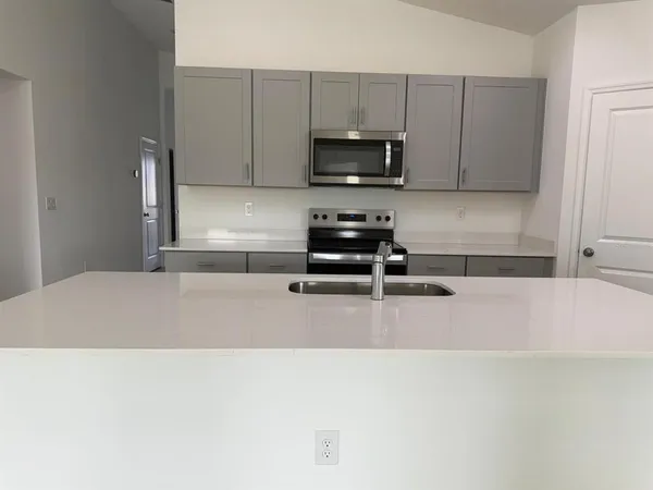 a kitchen with stainless steel appliances a microwave a sink and a refrigerator