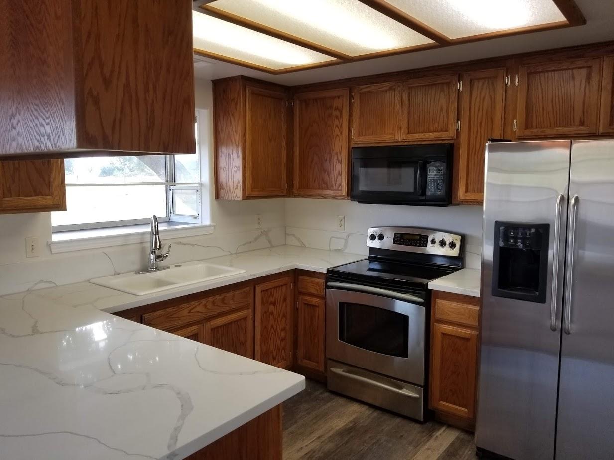 23135 Kindlespire Road Proberta, CA 96078 - Photo 4 of 33 a kitchen with granite countertop wooden cabinets stainless steel appliances and a window