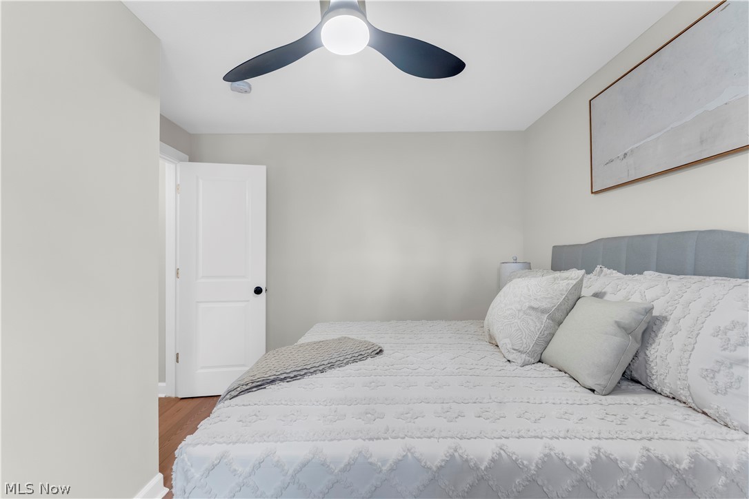 18155 Libby Road Maple Heights, OH 44137 - Photo 18 of 32 Spacious room featuring wood-finish flooring, light grey painted walls, a modern ceiling fan, and a white interior door with a black knob