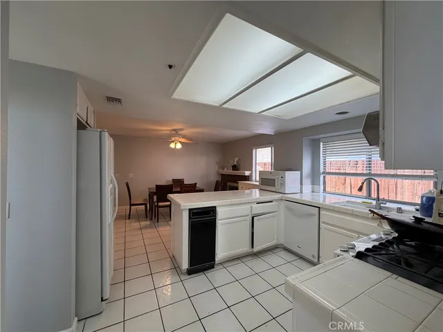 a kitchen with a sink and chairs