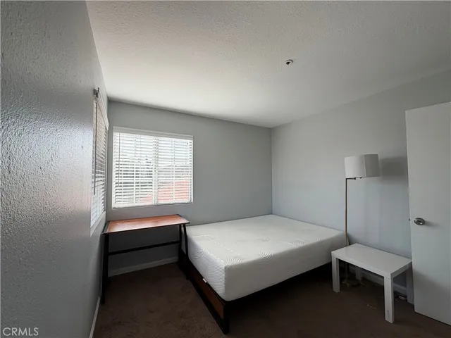 a bedroom with a bed a lamp and a window