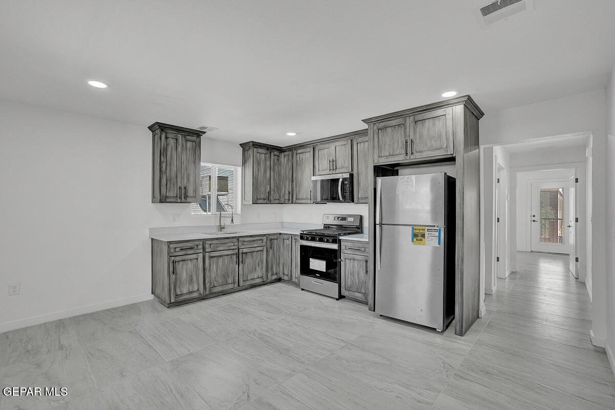 1107 Myrtle Avenue, Unit AD El Paso, TX 79901 - Photo 16 of 33 a large kitchen with a refrigerator a sink dishwasher a stove and a refrigerator with wooden floor