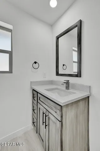 an empty room with wooden floor ceiling fan and windows