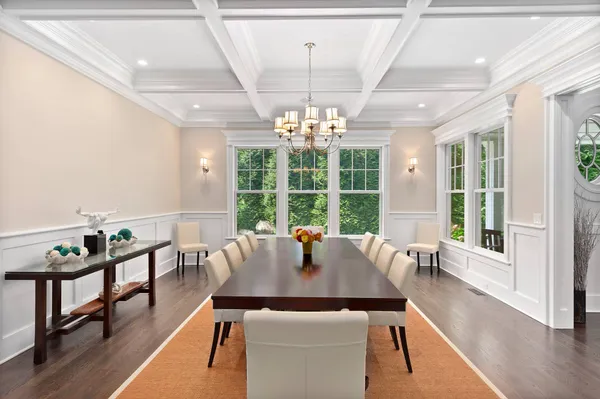 a view of a dining room with furniture a chandelier and wooden floor