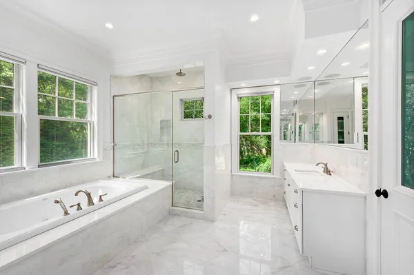 a bathroom with a tub a sink and mirror
