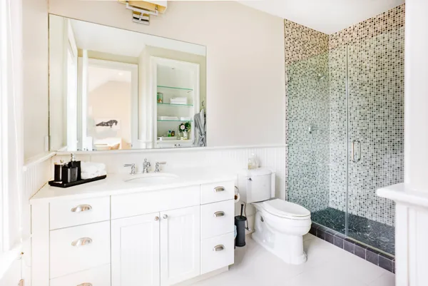 a bathroom with a sink toilet vanity and shower