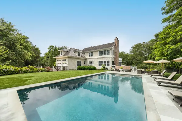 a view of a swimming pool with a garden and trees