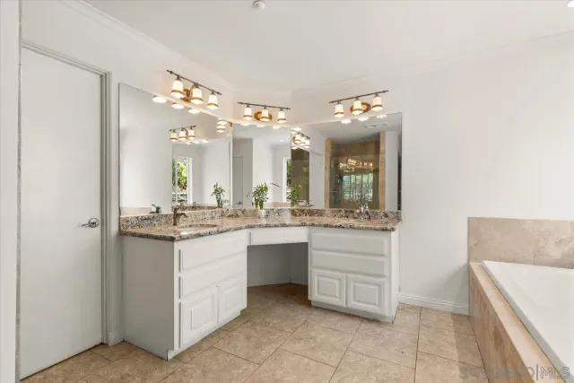 a bathroom with a granite countertop tub a double vanity and a sink