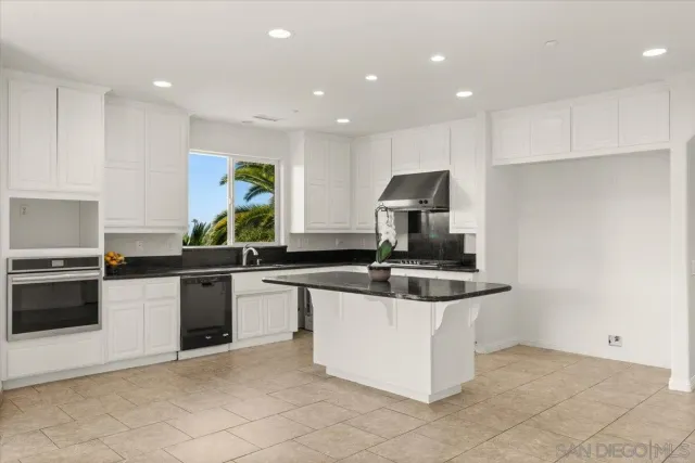 a kitchen with stainless steel appliances granite countertop a sink and a stove
