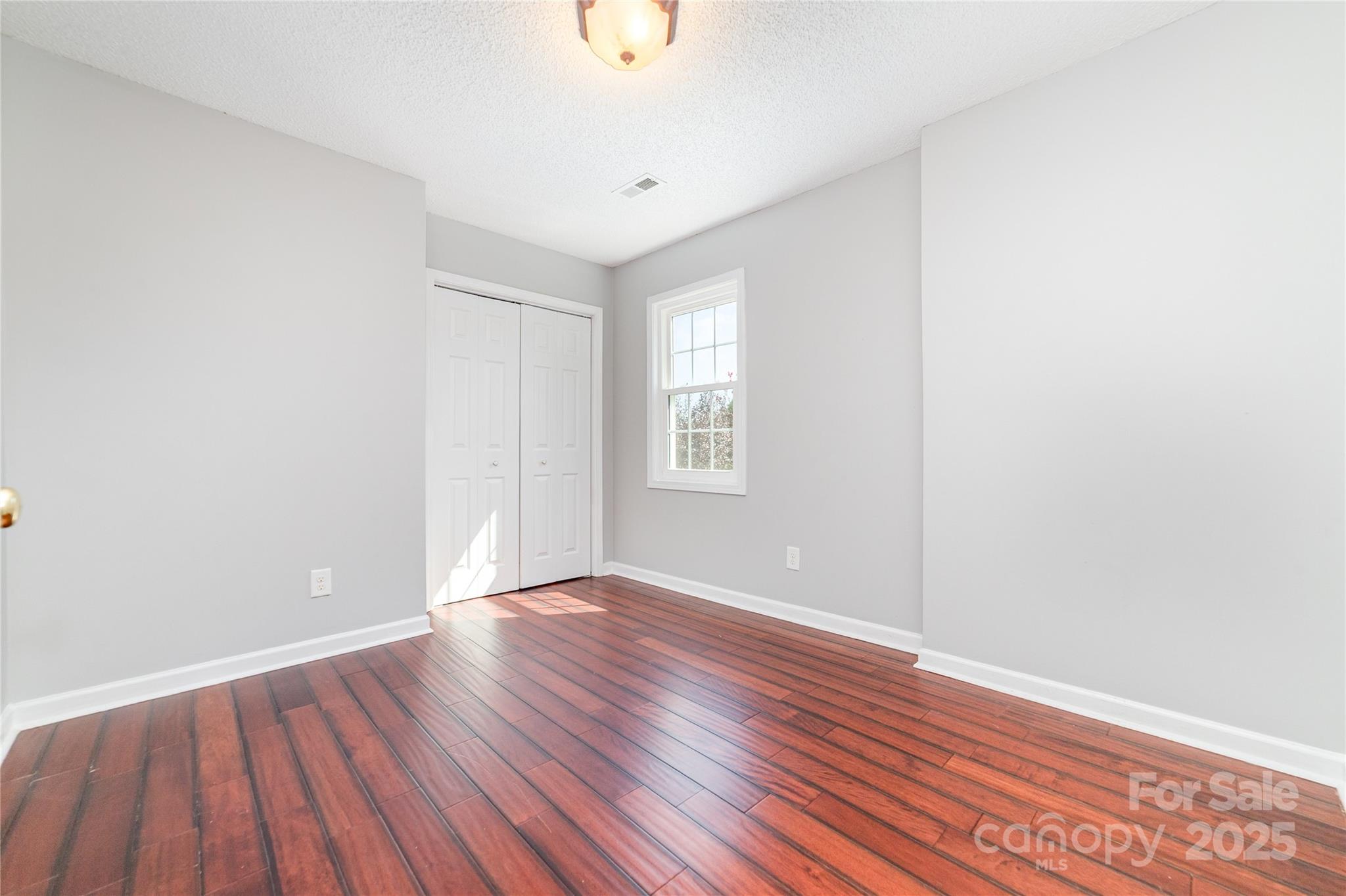 200 Sidney Court Monroe, NC 28110 - Photo 12 of 18 a view of an empty room with wooden floor and a window