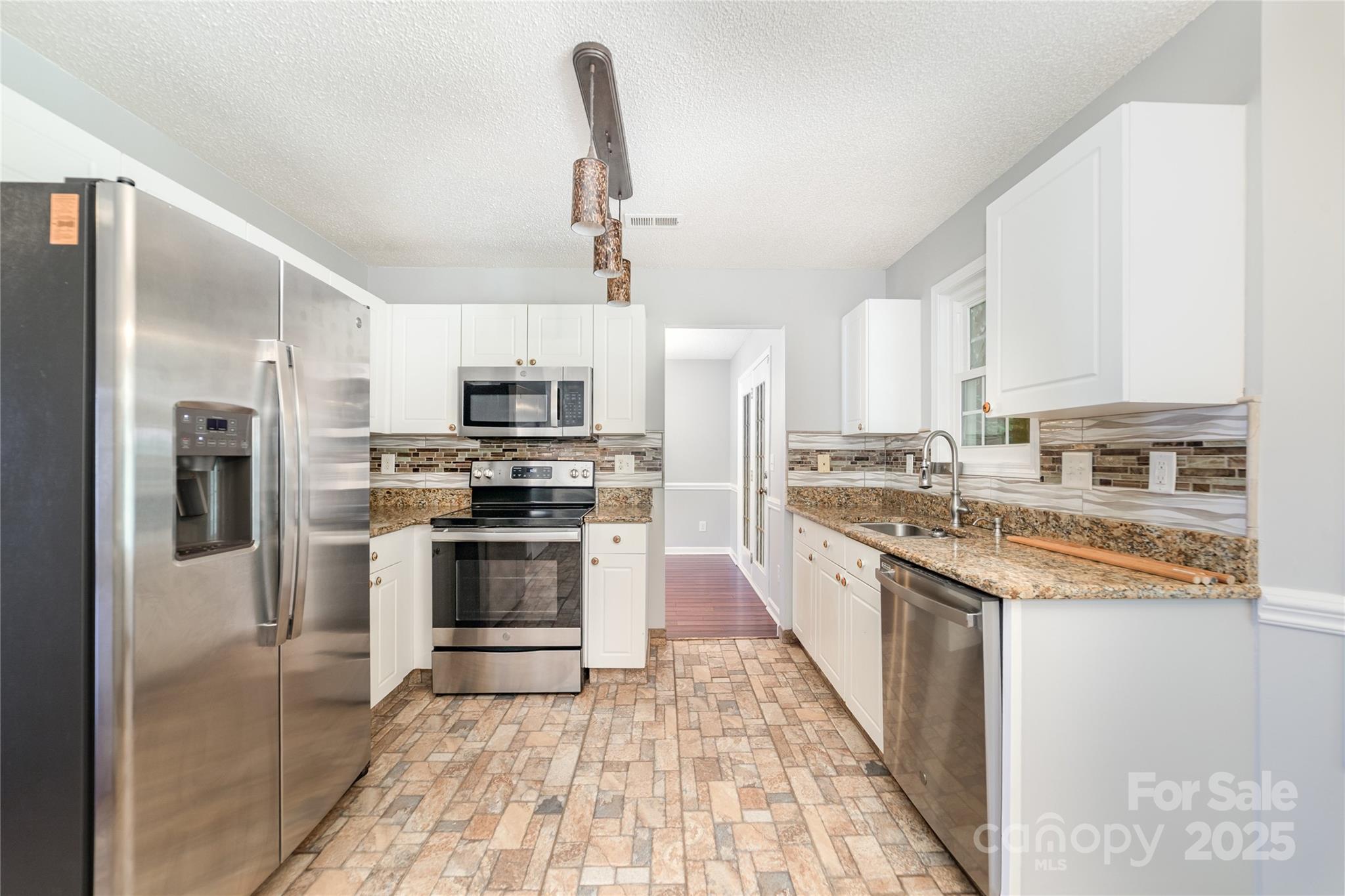 200 Sidney Court Monroe, NC 28110 - Photo 6 of 18 a kitchen with stainless steel appliances granite countertop a stove top oven a sink and white cabinets