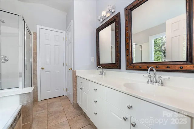 a bathroom with a double vanity sink mirror and next to a window