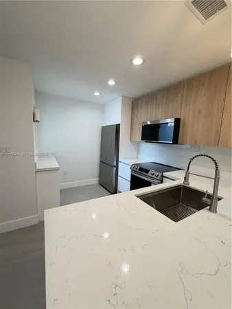 a kitchen with stainless steel appliances a refrigerator sink and cabinets