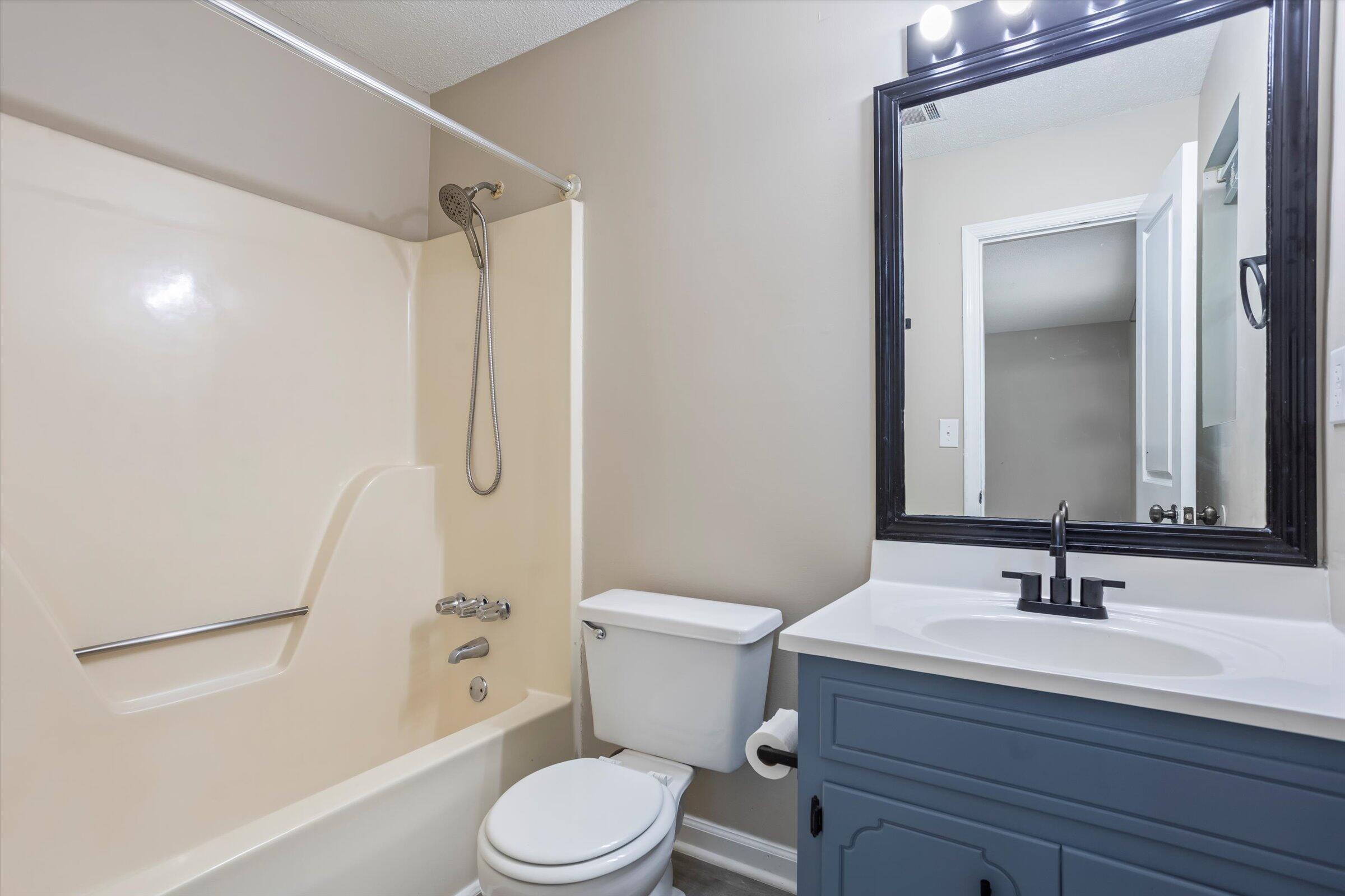 305 Manchester Court Grovetown, GA 30813 - Photo 12 of 13 a bathroom with a sink a mirror a toilet and shower