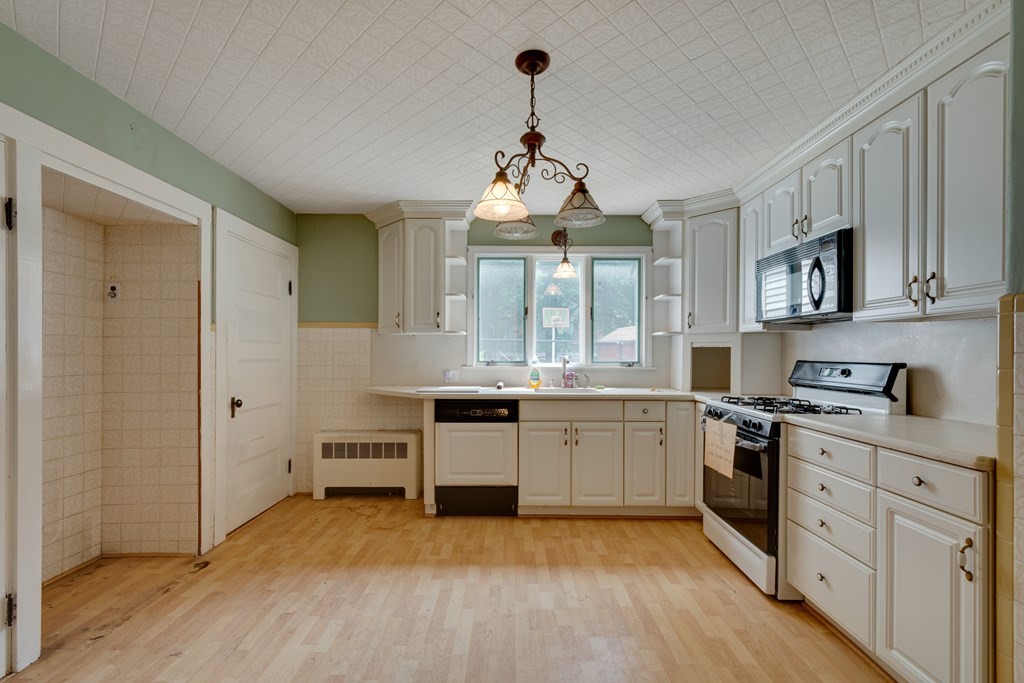 33 Oak Street Boston, MA 02136 - Photo 11 of 18 a large kitchen with cabinets wooden floor and stainless steel appliances