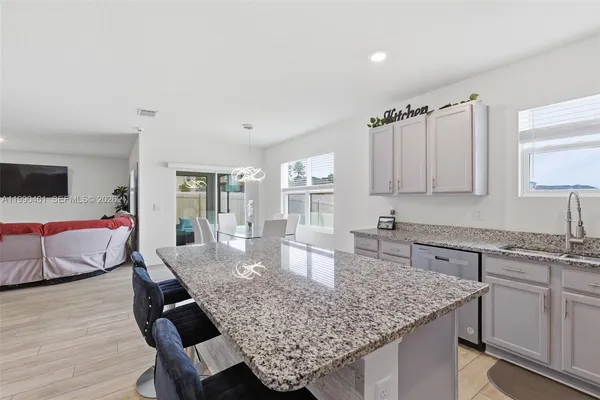 a kitchen with granite countertop kitchen island stainless steel appliances a sink and cabinets