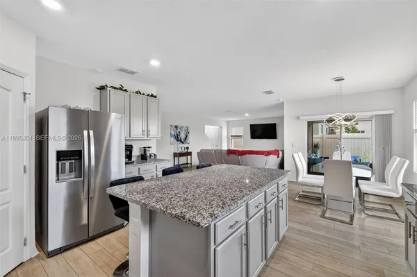 a kitchen with stainless steel appliances granite countertop a kitchen island a stove and a sink