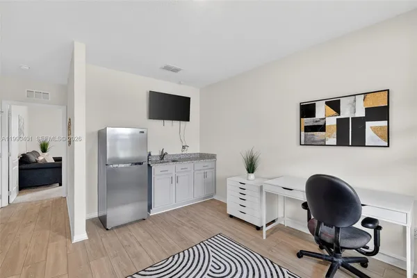 a work room with furniture and a flat screen tv