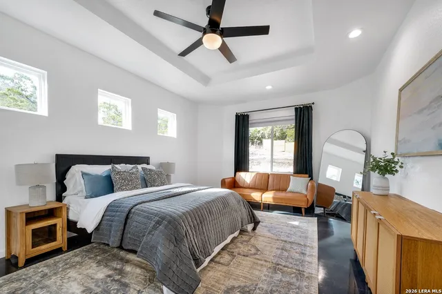 a bedroom with a balcony furniture and a window