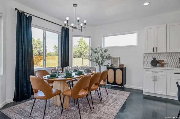 a dining room with furniture a chandelier and wooden floor