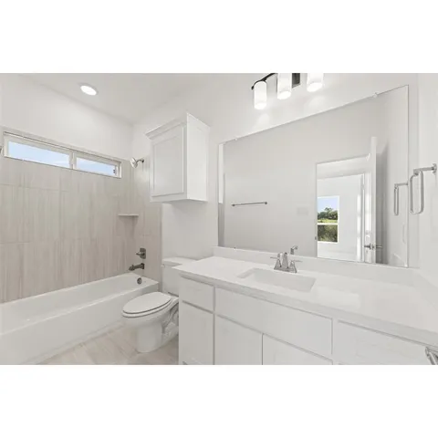 a bathroom with a sink vanity granite tub and a mirror