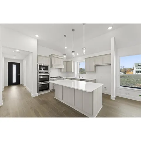 a view of kitchen with kitchen island a sink stainless steel appliances and cabinets