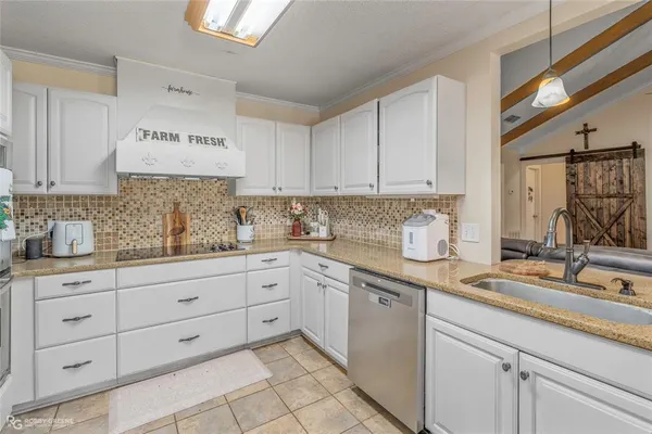 a kitchen with granite countertop white cabinets and white appliances