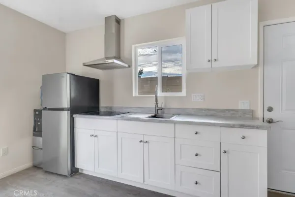 a kitchen with granite countertop white cabinets and a sink