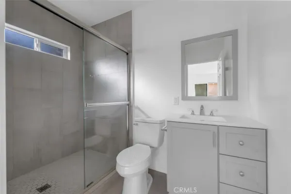 a bathroom with a toilet sink vanity and mirror