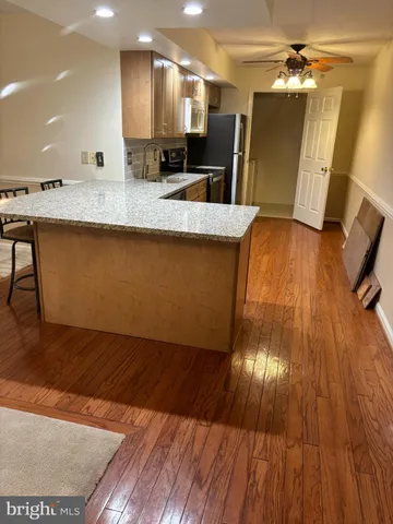 a view of a kitchen counter space a sink wooden floor and a kitchen view