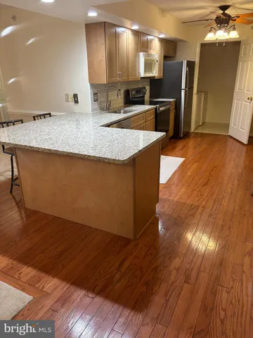 a kitchen with stainless steel appliances granite countertop a sink a oven and a large refrigerator