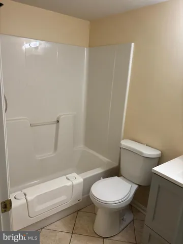 a white toilet sitting next to a bath tub