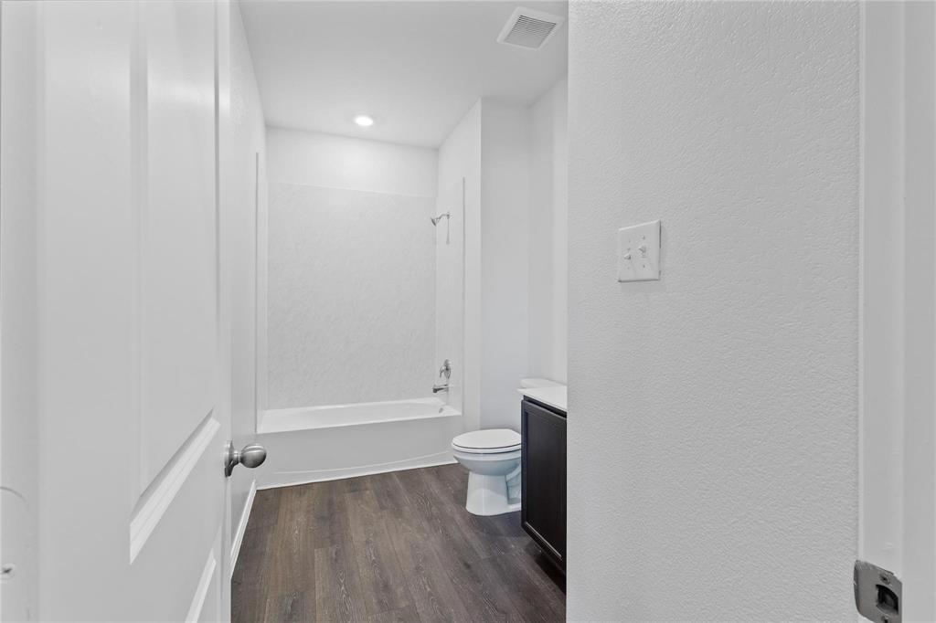 1287 Delmita Drive, Unit 1287 Forney, TX 75126 - Photo 15 of 23 Full bath featuring vanity, a textured wall, dark wood-type flooring, and shower / bathtub combination