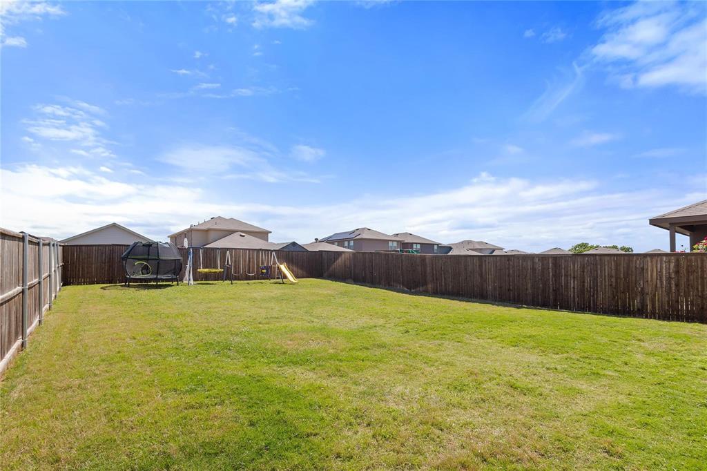 1287 Delmita Drive, Unit 1287 Forney, TX 75126 - Photo 19 of 23 Fenced backyard featuring a trampoline, a residential view, and a playground