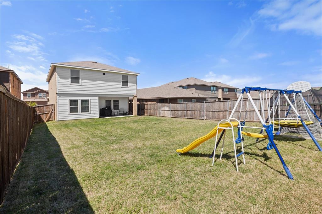 1287 Delmita Drive, Unit 1287 Forney, TX 75126 - Photo 20 of 23 Back of house featuring a playground, a patio area, a fenced backyard, and a residential view