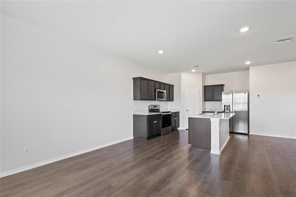 1287 Delmita Drive, Unit 1287 Forney, TX 75126 - Photo 22 of 23 Kitchen with appliances with stainless steel finishes, a kitchen island with sink, dark wood-style flooring, recessed lighting, and open floor plan